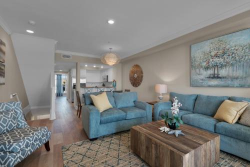 a living room with blue couches and a coffee table at Bikini Bottom by Gulf Coast Getaways in Navarre