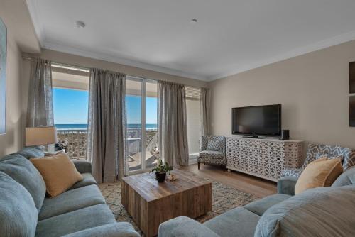 a living room with a blue couch and a television at Bikini Bottom by Gulf Coast Getaways in Navarre