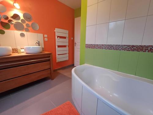 une salle de bain avec une baignoire et un lavabo dans l'établissement Family home Les Collines, à Bègues