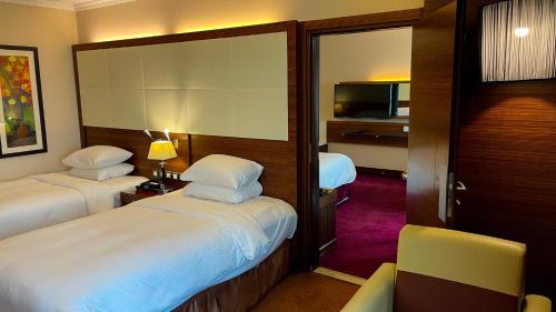 a hotel room with two beds and a television at Crowne Plaza Amman by IHG in Amman