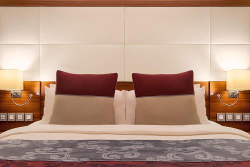 a bedroom with a large bed with two pillows at Crowne Plaza Amman by IHG in Amman
