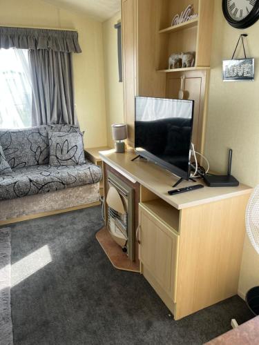 a living room with a desk with a television on it at B&T caravans in Ingoldmells