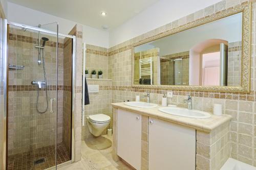 une salle de bain avec deux lavabos et une douche dans l'établissement Villa Baie des Issambres, à Sainte-Maxime