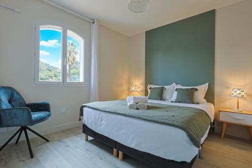 une chambre avec un lit, une chaise et une fenêtre dans l'établissement Villa Baie des Issambres, à Sainte-Maxime