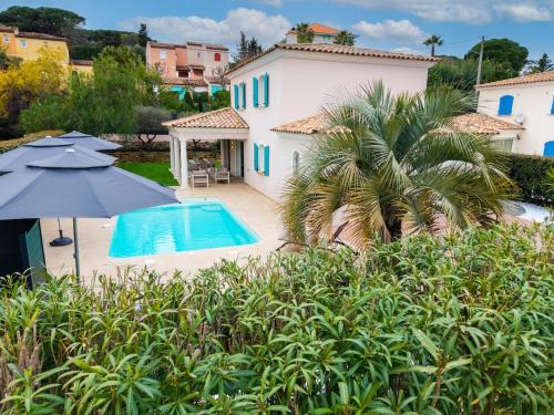 une maison avec une piscine et un parasol dans l'établissement Villa Baie des Issambres, à Sainte-Maxime