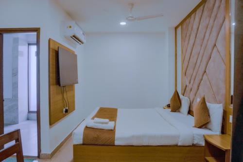 a hotel room with a bed and a television at Hotel Lake View Chandigarh in Chandīgarh