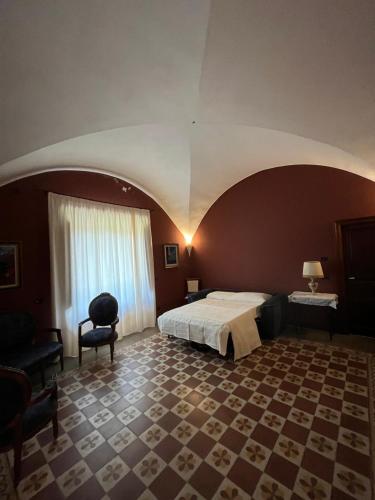 a bedroom with a bed and a chair in a room at Agriturismo Tenute Spartà in Randazzo
