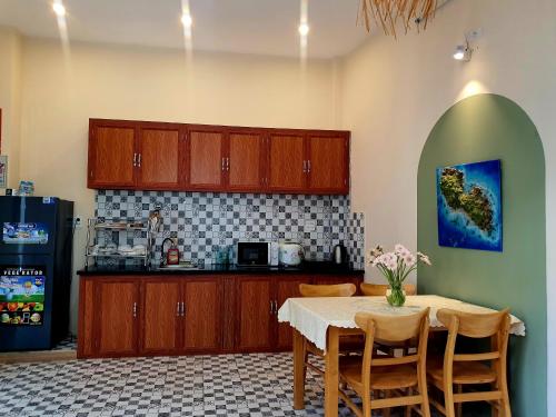 a kitchen with a table with chairs and a refrigerator at Sông Suối homestay 2 in Quy Nhon