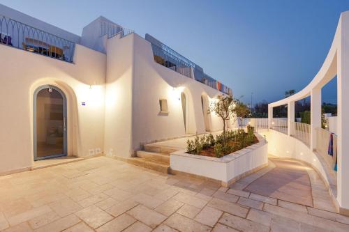 a large white building with stairs and a courtyard at La Corte Relais in Torre Pali 
