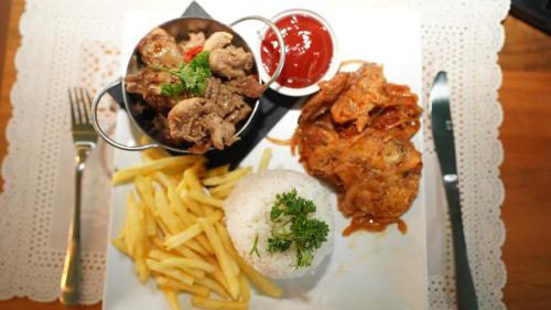 a plate of food with meat and french fries at El Kaoba in Cabarete