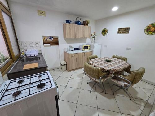 a kitchen with a stove and a table and a stove top oven at Charming rustic getaway in Xaghra, Gozo. in Xagħra