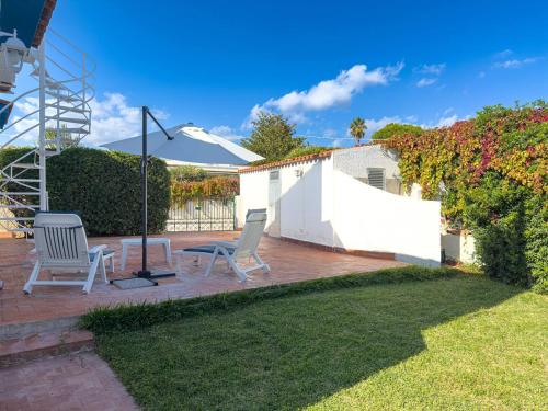 a patio with two chairs and an umbrella at Villa Leandra in Fontane Bianche