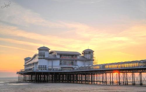 a large building on a pier next to the ocean at Vintage Vibes in Weston-super-Mare