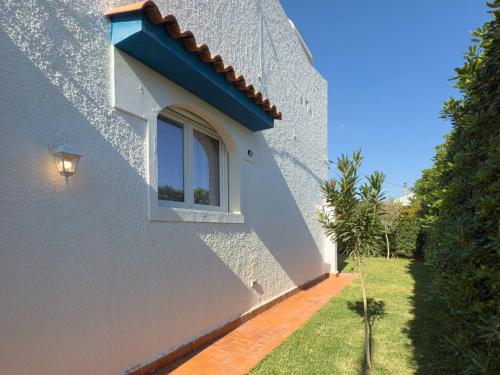 a window on the side of a white building at Villa Leandra in Fontane Bianche