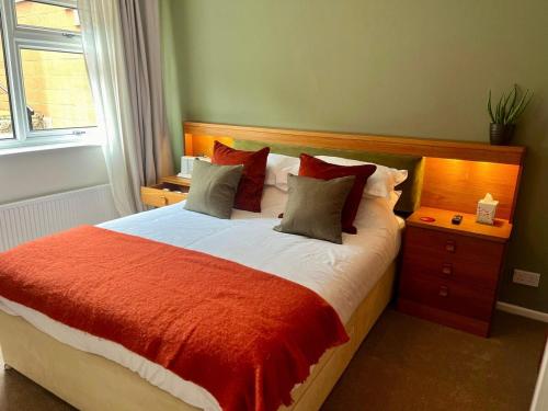 a bedroom with a bed with a red and white comforter at Vintage Vibes in Weston-super-Mare