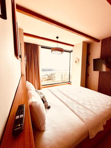 a hotel room with a bed with a window at The May Five - Adults only in Seferihisar