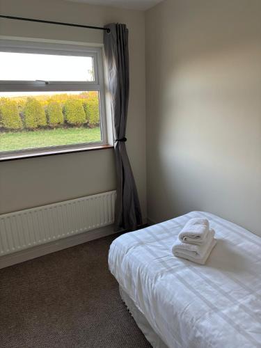 a bedroom with a bed and a window with a towel on it at Hillside Home in Donegal