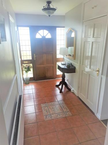 a hallway with a door and a tile floor at Hillside Home in Donegal