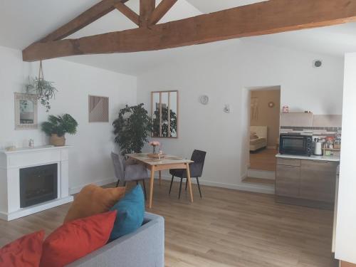 une personne assise sur un canapé dans un salon dans l'établissement Maison de charme bord de rivière, à Le Chay