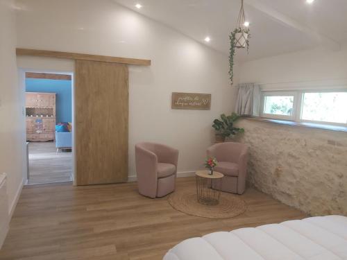 un salon avec un canapé, deux chaises et une table dans l'établissement Maison de charme bord de rivière, à Le Chay