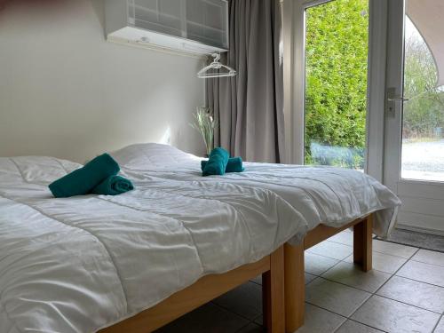 a bed with two blue pillows on it in a bedroom at Vakantiehuis Atthis in Ermelo