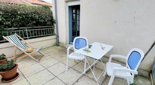 une table blanche et des chaises sur un balcon dans l'établissement 170 - Le Clémenceau, à Saint-Martin-de-Ré