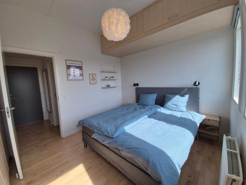 a bedroom with a large bed with a blue comforter at Urban Stay Herning in Herning