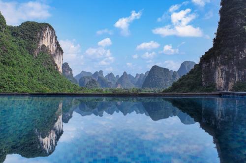 a large body of water with mountains in the background at Lanshan Moon Resort in Yangshuo