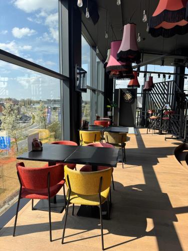 a restaurant with tables and chairs and windows at Hof van Stayen in Sint-Truiden