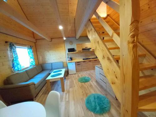 a living room with a couch and a staircase in a tiny house at Domki na kamieńcu 47c in Ustrzyki Dolne