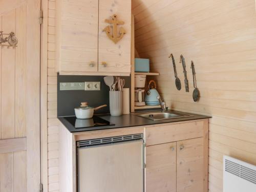 a small kitchen with a sink and a stove at Iglucraft Tiny Haus im Naheland I Grill I Wasserspielpatz I W-LAN in Heddesheim