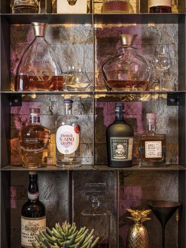 a shelf filled with different types of bottles and glasses at Hotel Bergkristall Zillertal - Adults Only in Hippach