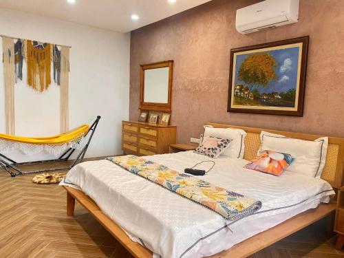 a bedroom with a bed and a chair in it at VILLA VENUS -Khu B Không mất vé cổng - tại Khu du lịch sinh thái Đại Lải in Thanh Cao
