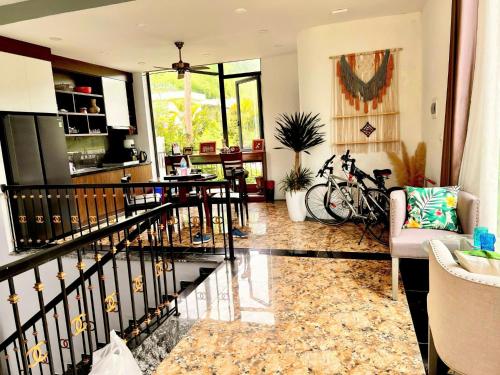 a living room with a staircase and a table at VILLA VENUS -Khu B Không mất vé cổng - tại Khu du lịch sinh thái Đại Lải in Thanh Cao