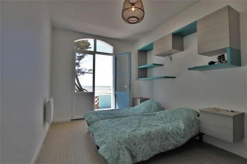 une chambre avec un lit dans une pièce avec une fenêtre dans l'établissement RARE Villa bord de mer, à La Tranche-sur-Mer