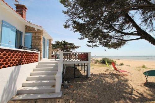 une maison avec des escaliers menant à la plage dans l'établissement RARE Villa bord de mer, à La Tranche-sur-Mer