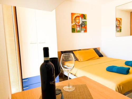a room with a bottle of wine and a table with a wine glass at Costa House in Cefalù