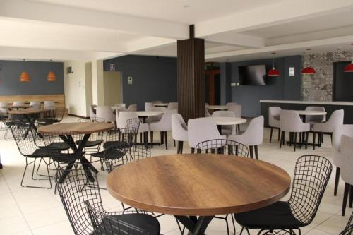 a restaurant with tables and white chairs and tables and tables at Hotel INTERnazionale in Ayacucho