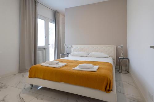 a bedroom with a bed with two towels on it at GuestHost - Lovely Apartment X4 in Central Rimini in Rimini