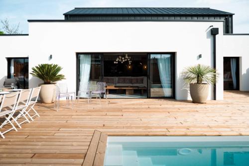un patio avec une table et des chaises et une piscine dans l'établissement Villa Loire Harmony, à Ancenis