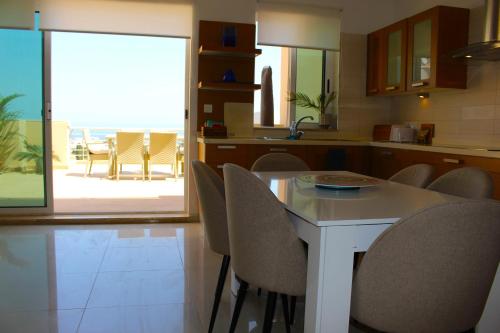 a kitchen with a white table and chairs and a patio at Beautiful 2 Floor Penthouse With Fabulous Views in Is-Swieqi