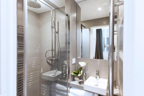 y baño con 2 lavabos y ducha. en Charming apartment in heart of Paris, en París