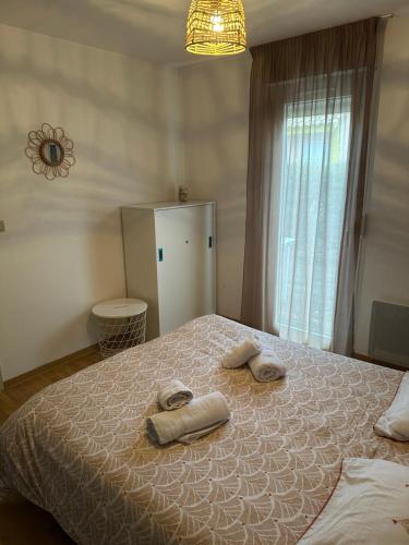 a bedroom with a bed with towels on it at Villa ROMA in Soustons