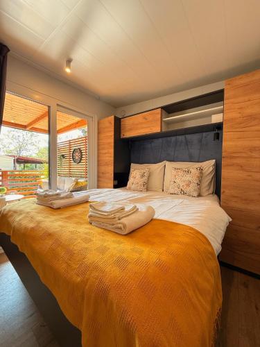 a bedroom with a large bed with towels on it at George Holiday Homes - Soline Beach in Biograd na Moru