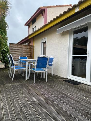a patio with a table and chairs on a deck at Villa ROMA in Soustons