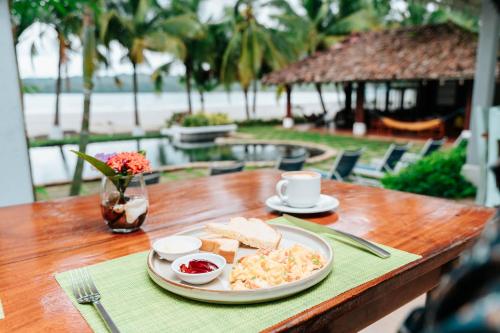 a table with a plate of food and a cup of coffee at Villa Marina Lodge & Condos in Playa Venao