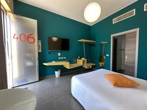 a bedroom with a white bed and a blue wall at ibis Styles Catania Acireale in Acireale
