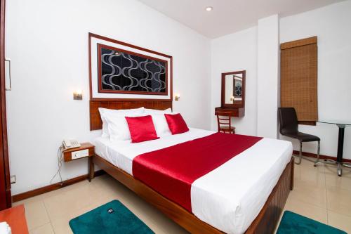 a bedroom with a large bed with a red blanket at Colour Moon Hotel in Kotagala