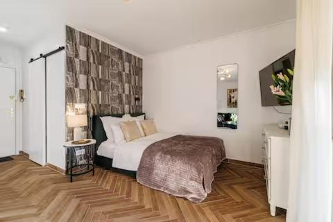 une chambre avec un grand lit et un parquet dans l'établissement Sunlight Properties - Suze Modern City Studio, à Beausoleil