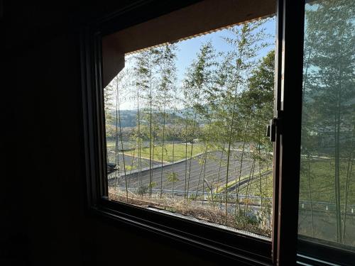 a window with a view of a field of trees at Osugi-ya 大杉屋 in Wazuka